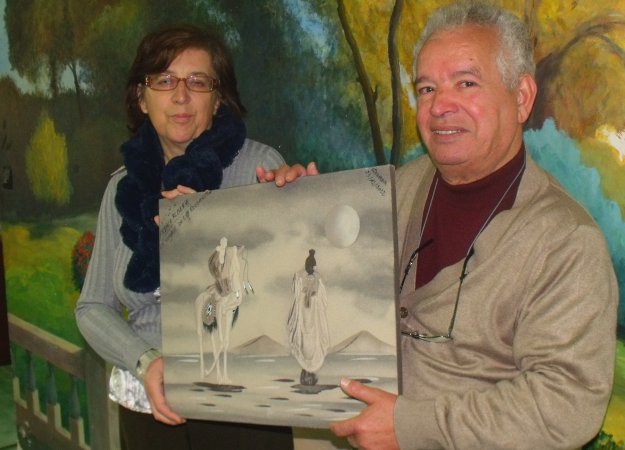 Rahim Rézigat et Denise Guiard tenant un tableau signé par tous les participants du voyage en Algérie